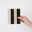 NU Wall Residence Light Oak and Black Slatted Wall Panel sample showing textured wood and black slats for modern interior design.