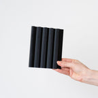Set of four NU Wall brushed black small slatted wall panels showing textured, modern design for interior wall decoration.
